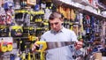 Confident man is choosing bucksaw in tools store