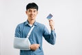 A confident man copes with a broken arm, using credit card Royalty Free Stock Photo