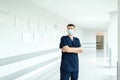 Confident man doctor wearing medical mask standing with crossed arms at hospital Royalty Free Stock Photo