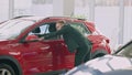 Confident man examining luxurious pricey car in dealership. Wide shot of successful wealthy Caucasian businessman