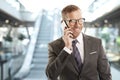 Confident man with mobile phone in shopping mall Royalty Free Stock Photo