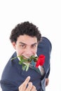 Confident man seducer in a suit holding a red rose in his mouth Royalty Free Stock Photo