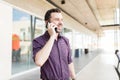 Man Talking With Friend Using Smartphone In Shopping Mall Royalty Free Stock Photo