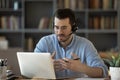 Confident man teacher wearing headset speaking, holding online lesson Royalty Free Stock Photo