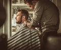 Confident man visiting hairstylist in barber shop.