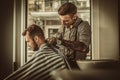 Confident man visiting hairstylist in barber shop.