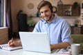 Confident man wearing headset speaking and watching business webinar training, listening to lecture Royalty Free Stock Photo