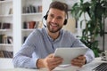 Confident man wearing headset speaking and watching business webinar training, listening to lecture Royalty Free Stock Photo