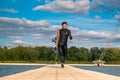 Confident man in wetsuit with wakeboard walking on floating bridge after training Royalty Free Stock Photo