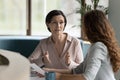 Confident mature business professional woman talking to younger female colleague