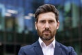 Confident mature businessman in suit posing in urban environment