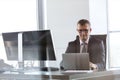 Confident mature businessman using laptop at desk in office Royalty Free Stock Photo