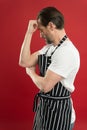 Confident mature handsome man in apron red background. He might be baker gardener chef or cleaner. Good in everything Royalty Free Stock Photo