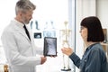GP showing x-ray on tablet to lady in cervical collar Royalty Free Stock Photo