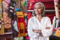 Confident mature woman standing in her colorful fabric shop Royalty Free Stock Photo