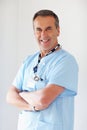 Confident medical doctor with hands folded against white. Portrait of a smiling medical doctor with hands folded against Royalty Free Stock Photo