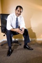 Confident middle-aged Hispanic businessman sitting