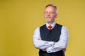 Confident middle aged man in shirt with crossed arms on his chest over yellow background Royalty Free Stock Photo