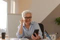 Confident middle aged senior woman euphoric winner with smartphone. Older mature lady looking at cell phone reading Royalty Free Stock Photo