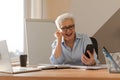 Confident middle aged senior woman euphoric winner with smartphone. Older mature lady looking at cell phone reading Royalty Free Stock Photo