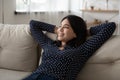 Young happy vietnamese woman rest on couch dream visualize success