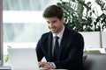 Confident millennial businessman sitting at desk working on laptop Royalty Free Stock Photo