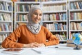Confident Muslim woman studying in a library setting Royalty Free Stock Photo