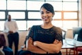 Confident in my teams abilities. Portrait of a confident young businesswoman standing in a modern office with her Royalty Free Stock Photo