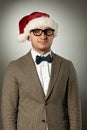 Confident nerd in Santa Claus hat and bow tie