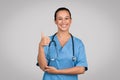 Confident nurse giving thumbs up in scrubs Royalty Free Stock Photo