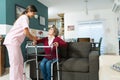 Caregiver Supporting Elderly Disabled Patient At Home