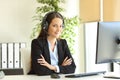 Confident office worker with headset looks at camera