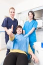 Confident patient with doctor and assistant showing thumb up Royalty Free Stock Photo