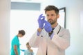 Confident pediatrician checking syringe at hospital