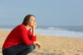 Confident pensive woman thinking on the beach