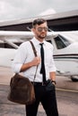 Confident pilot in sunglasses with bag