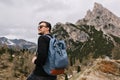 Confident pleased man with smile looking in the sky enjoying fresh mountain air during trip. Portrait of joyful tourist