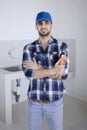 Confident plumber standing near a kitchen sink Royalty Free Stock Photo