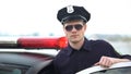 Confident police officer in uniform and sunglasses standing near patrol car Royalty Free Stock Photo