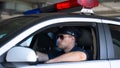 Confident policeman in sunglasses sitting in car, ready for area patrolling duty