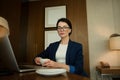 Confident portrait of a prosperous businessman, successful female sales manager looking at camera while sitting at the table and