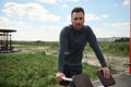 Confident portrait of an exhausted and tired male athlete in grey sportswear having rest after workout outdoors in beautiful Royalty Free Stock Photo