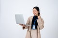 A confident Asian businesswoman a laptop and pointing her finger up, isolated white background Royalty Free Stock Photo