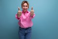 confident positive young blond caucasian woman model with ponytail hairstyle in a stylish look consisting of a pink Royalty Free Stock Photo