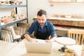 Confident Potter Using Laptop Computer At Table In Studio Royalty Free Stock Photo