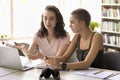 Confident pretty college achiever girl helping classmate with assignment