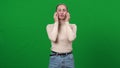 Confident professional actress making articulation warm-up at chromakey background. Portrait of beautiful slim Caucasian