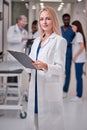 Confident Professional Female Doctor Posing At Camera Holding Clipboard in Hands Royalty Free Stock Photo