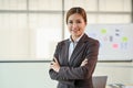 A confident Asian businesswoman stands with the meeting room with her arms crossed Royalty Free Stock Photo