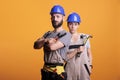 Confident professional renovators posing with pair of pliers and hammer Royalty Free Stock Photo